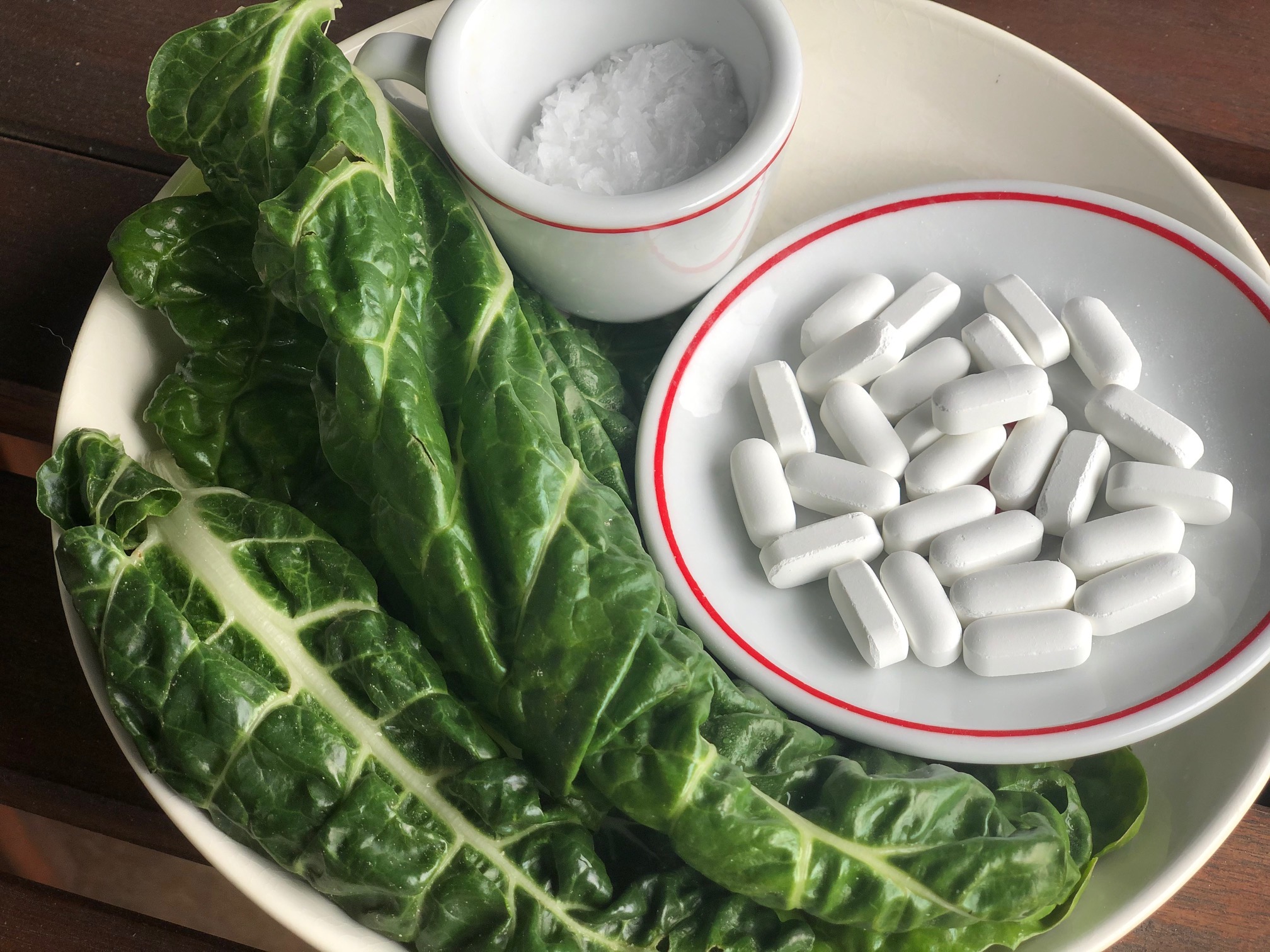 A Vivacity Acupuncture photograph showing various methods of magnesium intake: leafy greens (bottom left), tablets (center right) and Epsom salts (top center).